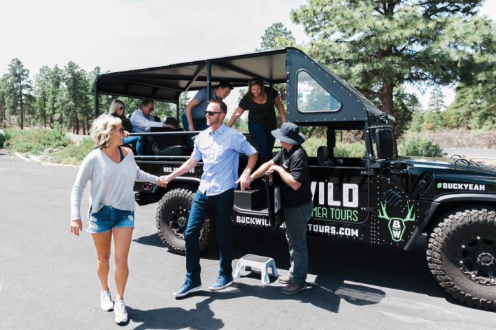 A tour is group smiles as they exit one of the custom hummers at the Grand Canyon private tour