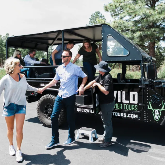 A tour is group smiles as they exit one of the custom hummers at the Grand Canyon private tour