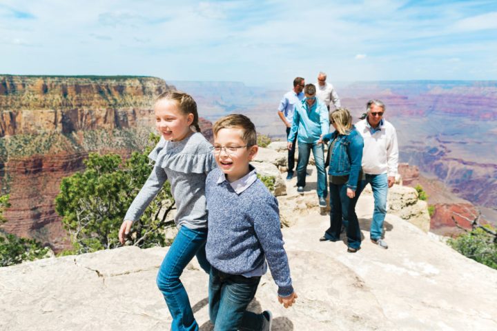 Two kids are all smilies as they gaze out at the Grand Canyon private tour