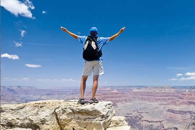 Man standing on edge of Grand Canyon South Rim after bus tour from Las Vegas