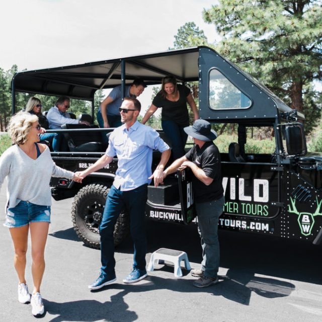 A tour is group smiles as they exit one of the custom hummers at the Grand Canyon private tour