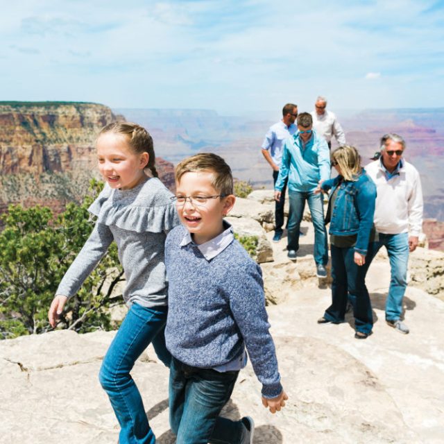 Two kids are all smilies as they gaze out at the Grand Canyon private tour