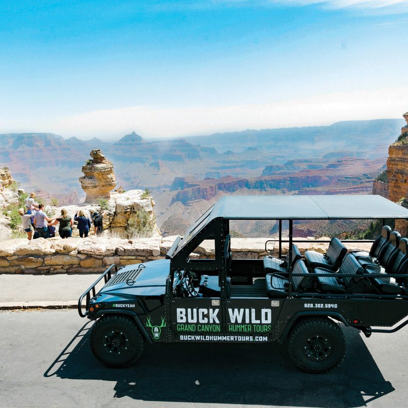 A car in front of the grand canyon
