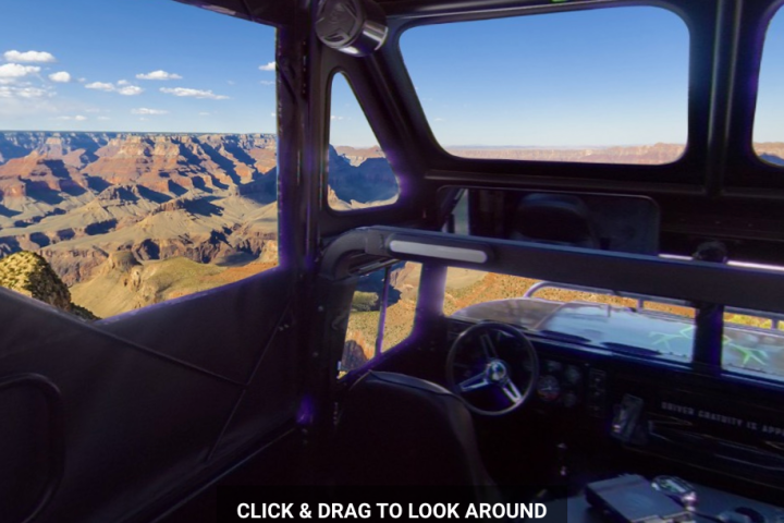 Interior of a vehicle with mountain view through windows.